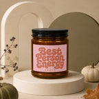Amber candle with black lid, "Best Person Energy" text on pink label.