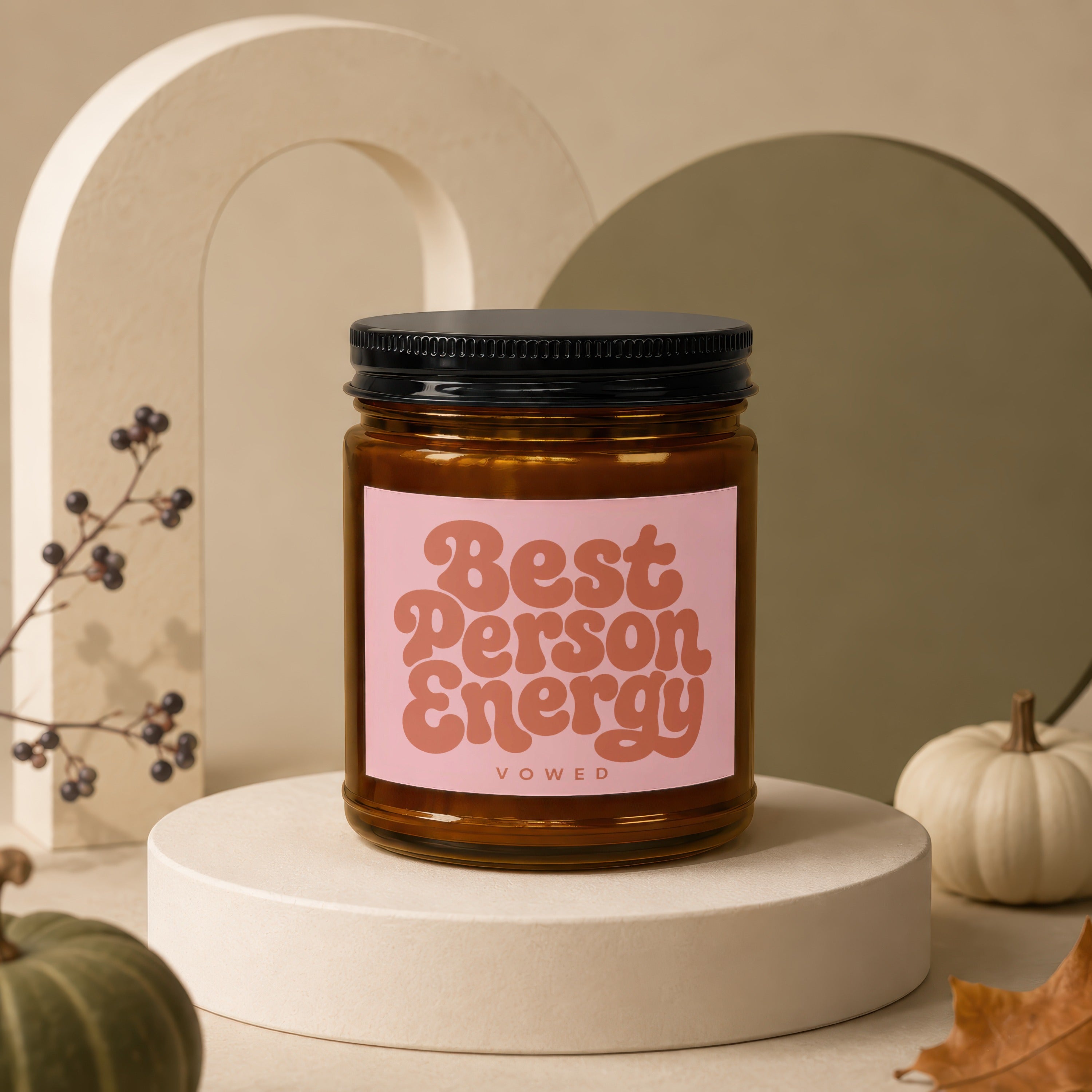 Amber candle with black lid, "Best Person Energy" text on pink label.