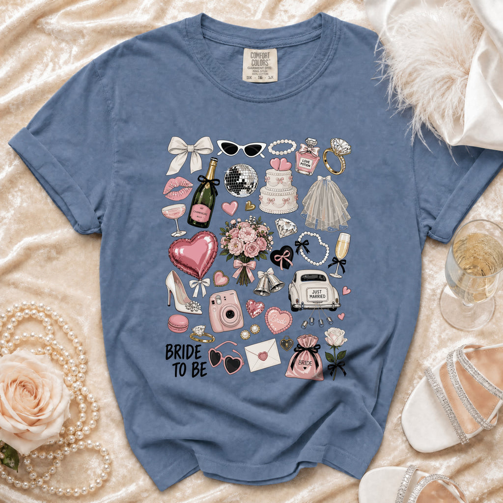 Blue t-shirt with "Bride to Be" and wedding icons including cake, champagne, and rings.