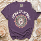 Purple t-shirt with "Mother of the Bride Raising a Princess Surviving Halloween Season" graphic.