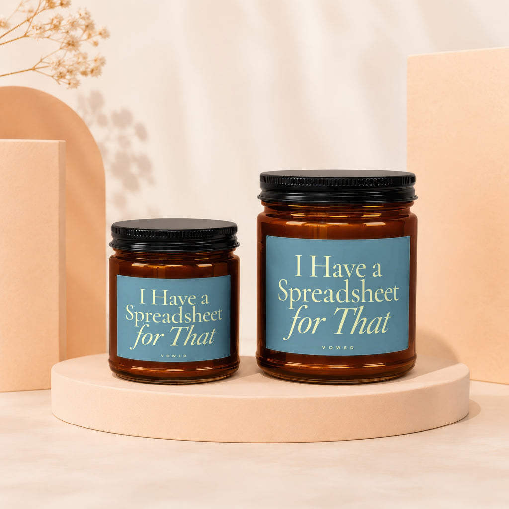 Two amber glass jar candles with black lids, labels read "I Have a Spreadsheet for That".