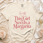 Cream t-shirt with "This Girl Needs a Margarita" graphic and margarita glass.