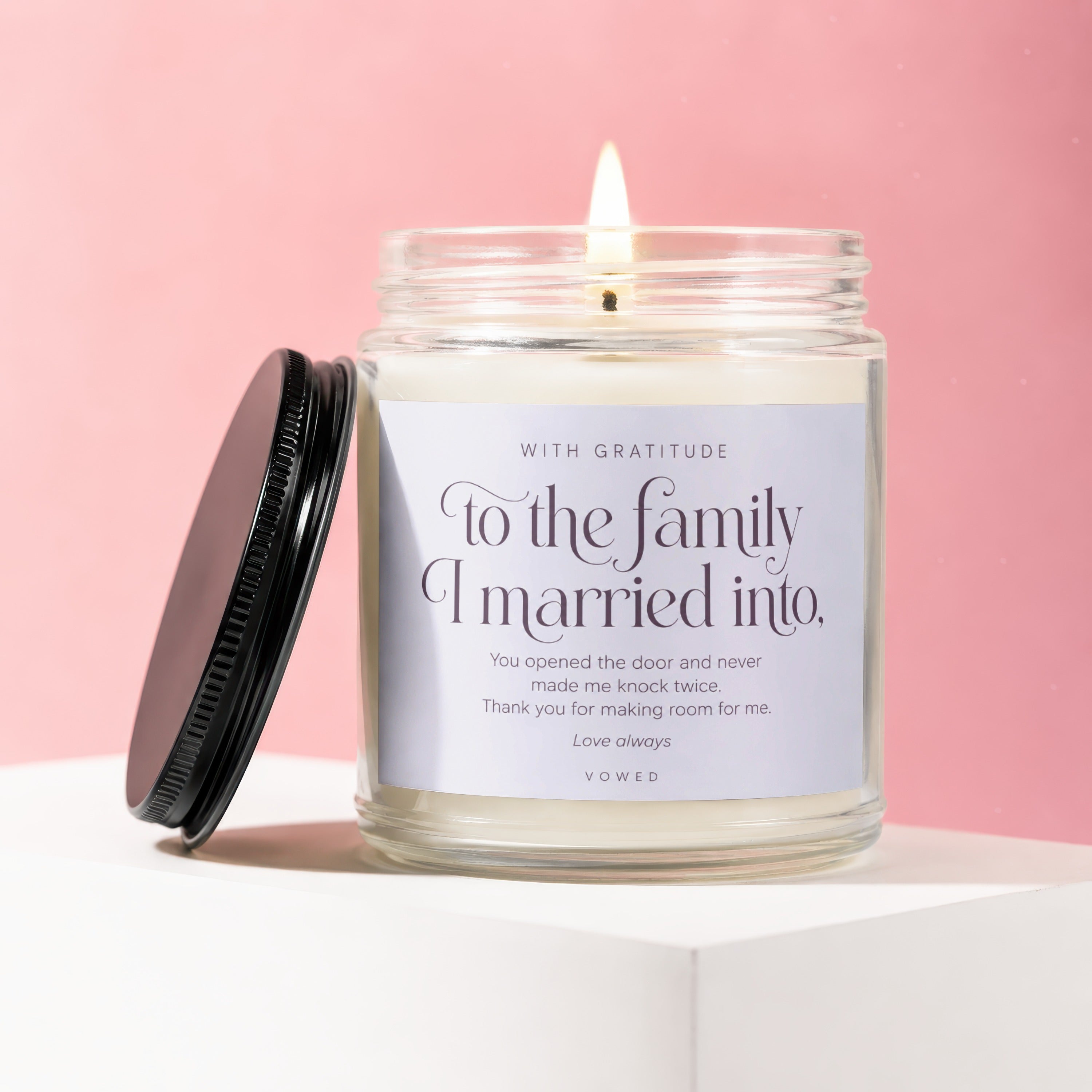 Candle with "To the family I married into" text on a pink background.