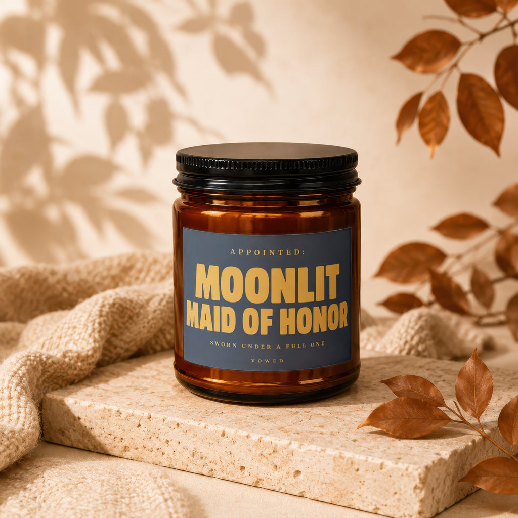 Amber jar candle with a navy label reading "MOONLIT MAID OF HONOR".