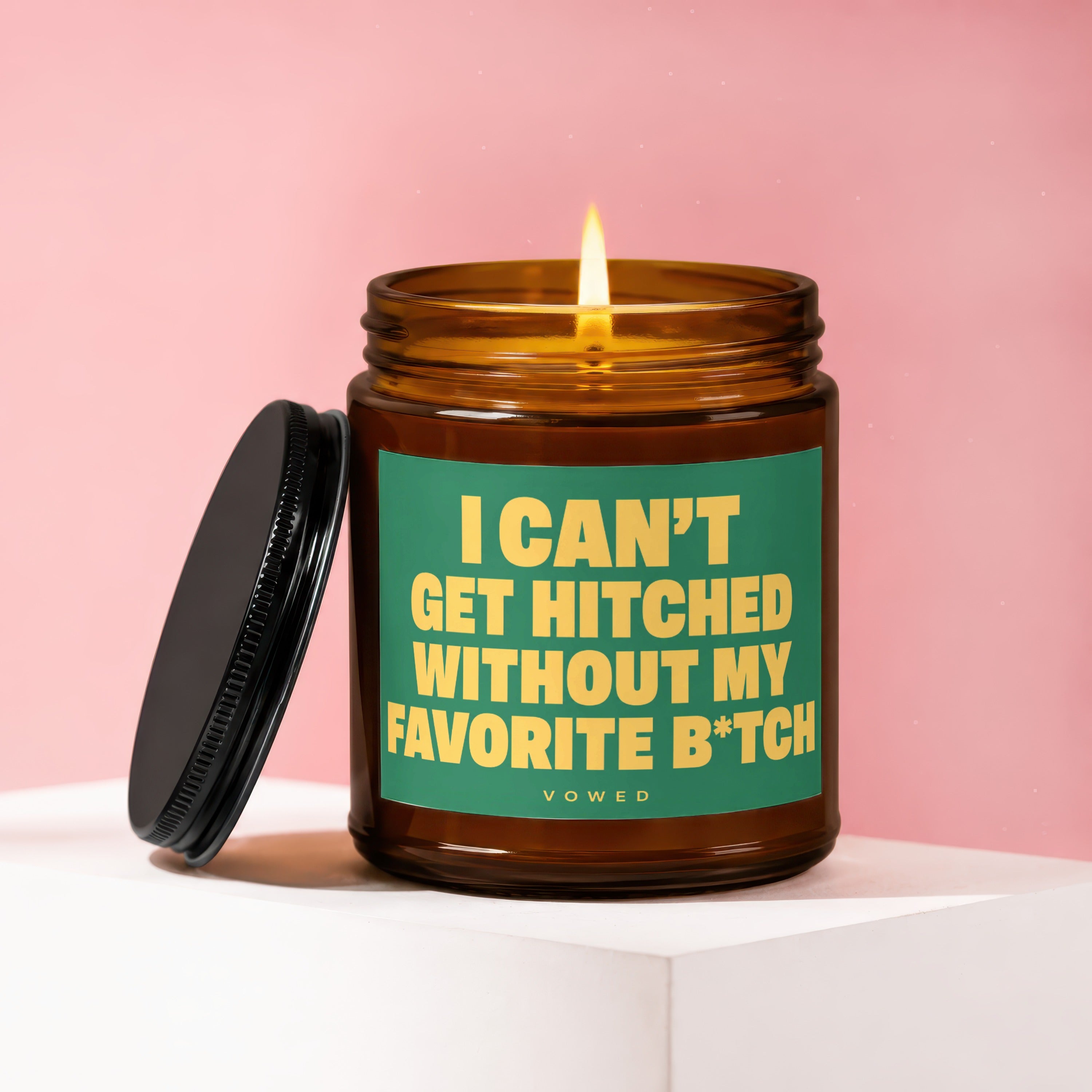 Amber candle with lit flame and green label reading "I CAN'T GET HITCHED WITHOUT MY FAVORITE B*TCH".