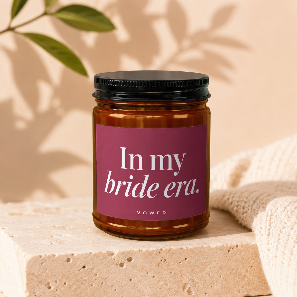 Amber jar candle with a magenta label saying "In my bride era. VOWED".