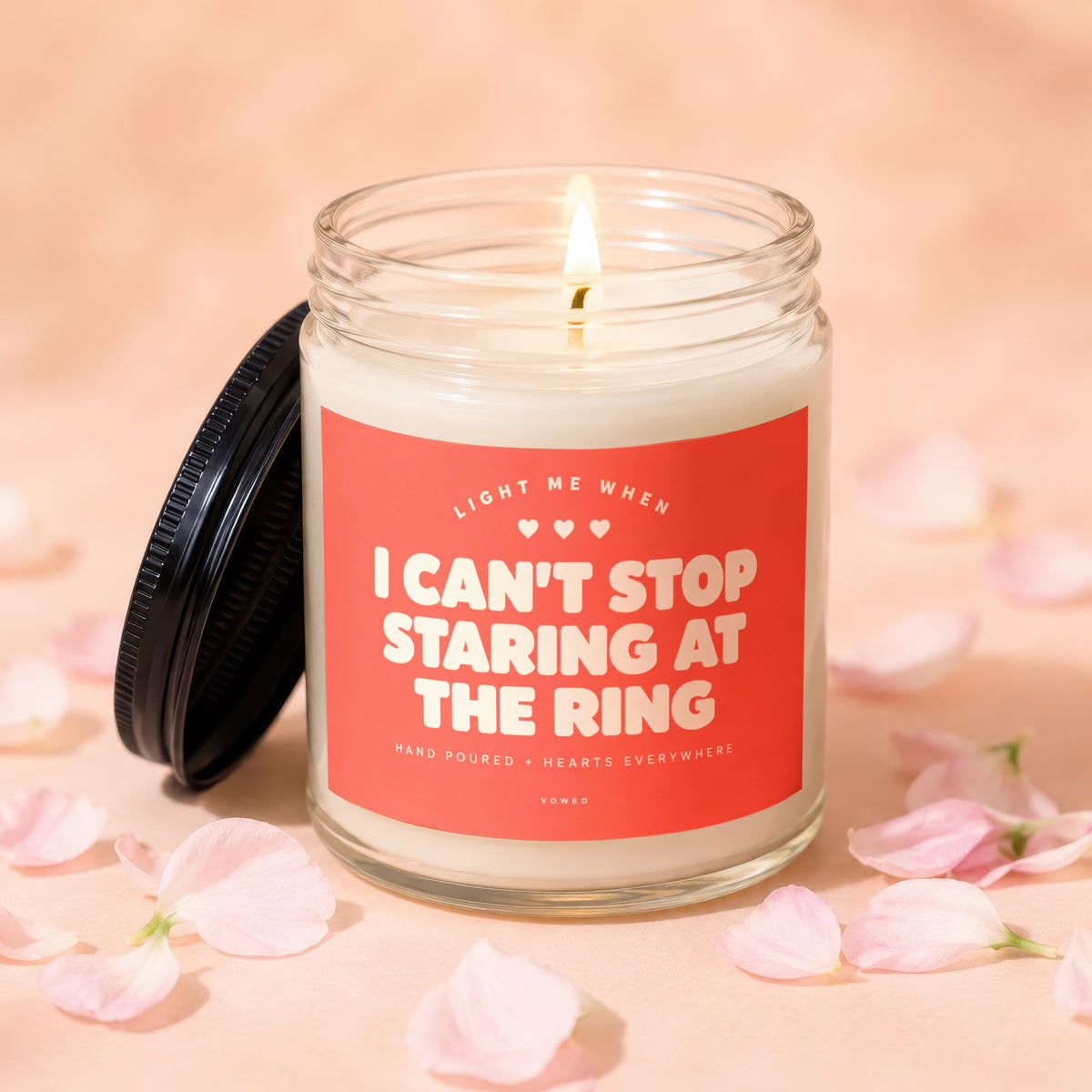 Lit candle in glass jar with "I Can't Stop Staring At The Ring" text.