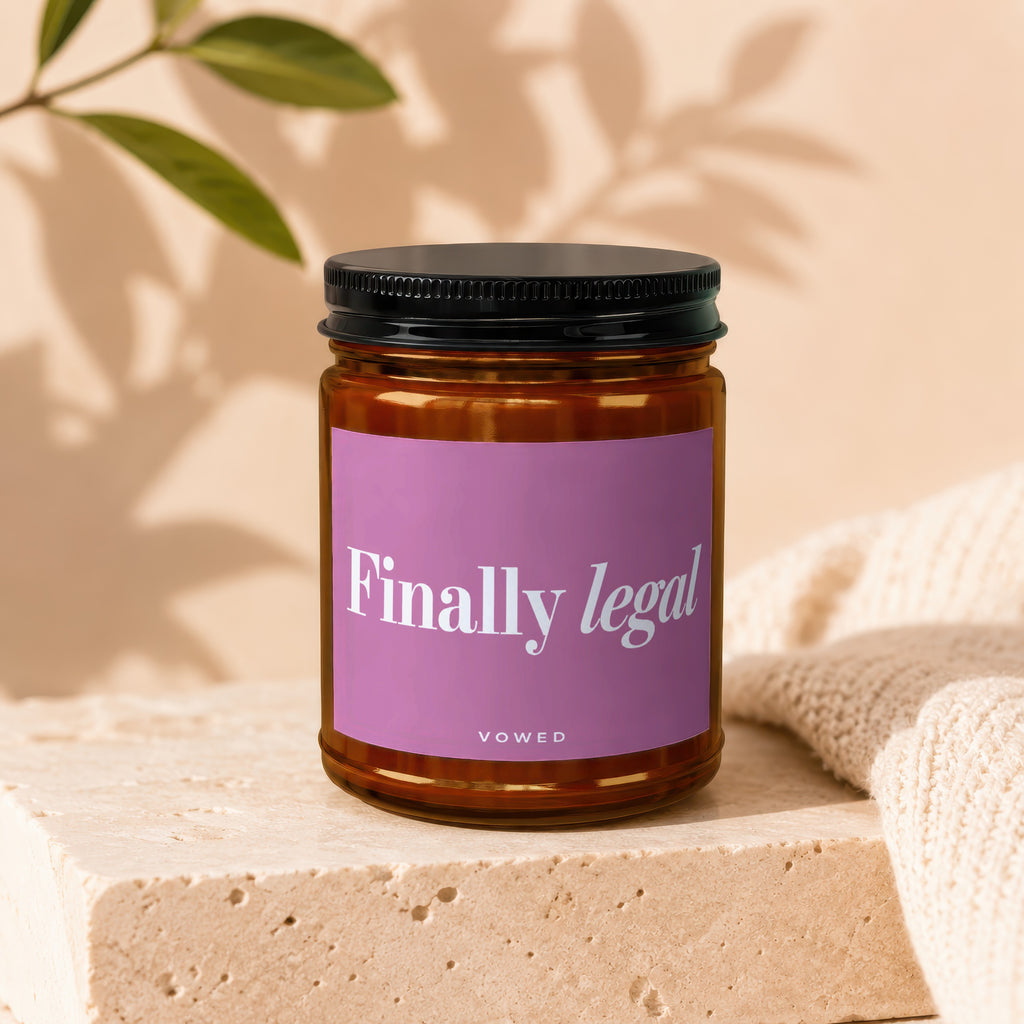 Amber jar candle with pink label reading "Finally legal" and "VOWED".