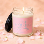 Candle with pink label reading "JUST MARRIED. Finally." surrounded by petals.
