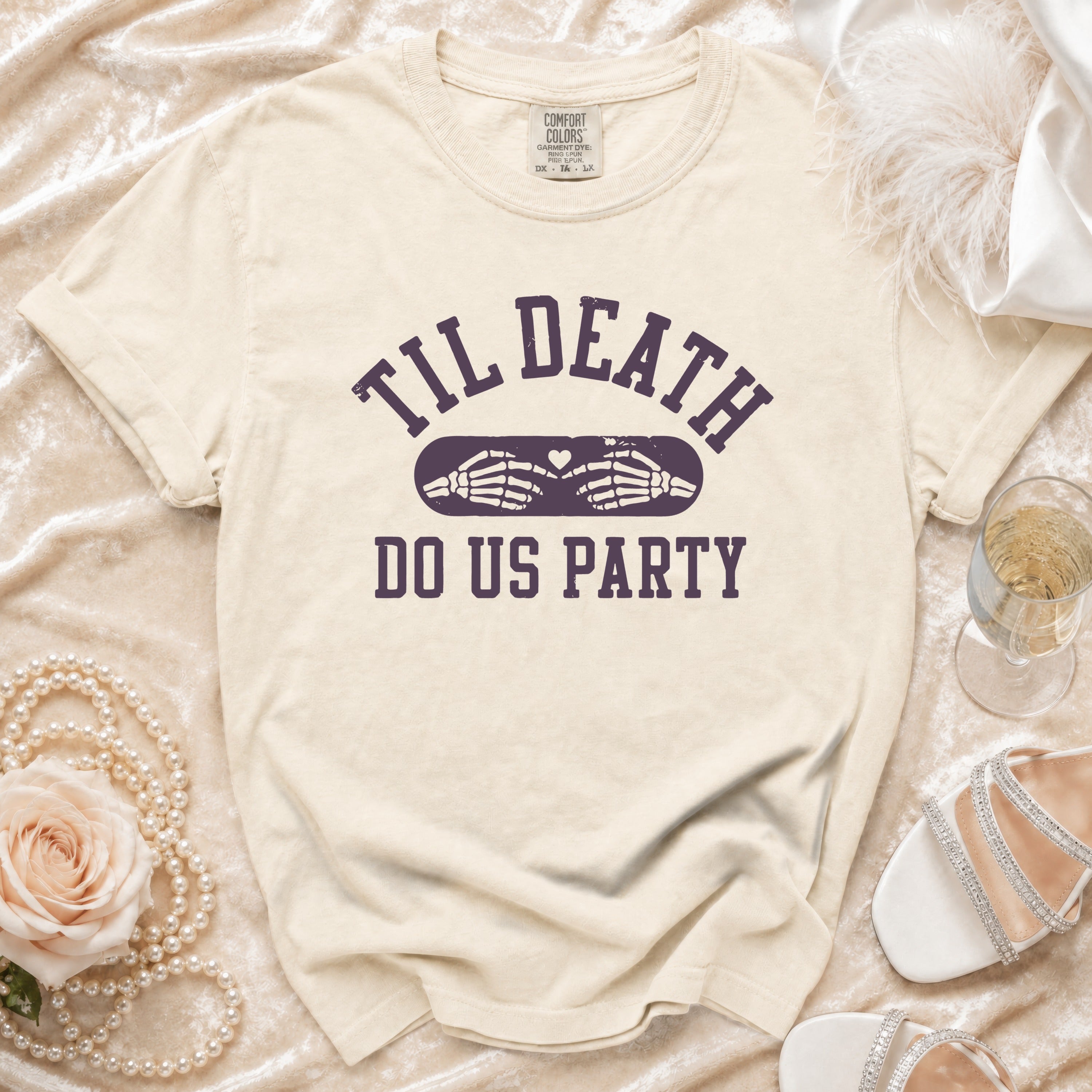Cream t-shirt with "Til Death Do Us Party" text and skeleton hands.