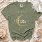 Green t-shirt with "Written In The Stars" text, moon, wedding rings, and stars design.