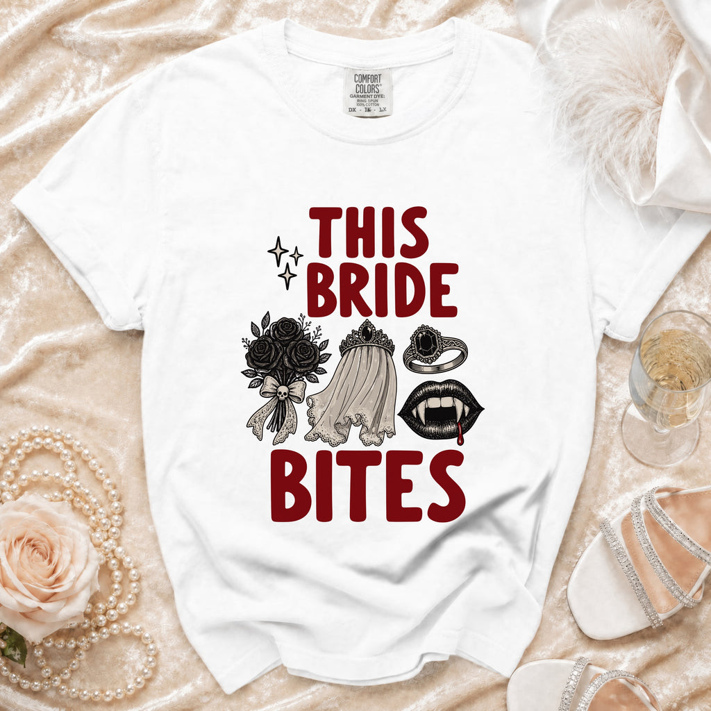 White t-shirt with "This Bride Bites" graphic featuring a bouquet, veil, ring, and fangs.