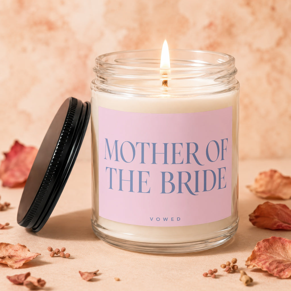 Glass candle with pink label, "Mother of the Bride" text, and a lit wick.
