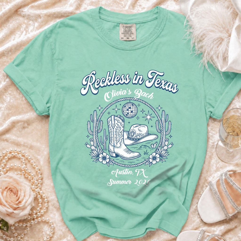 "Reckless in Texas" graphic tee with cowboy boots and hat for Olivia's Bach.