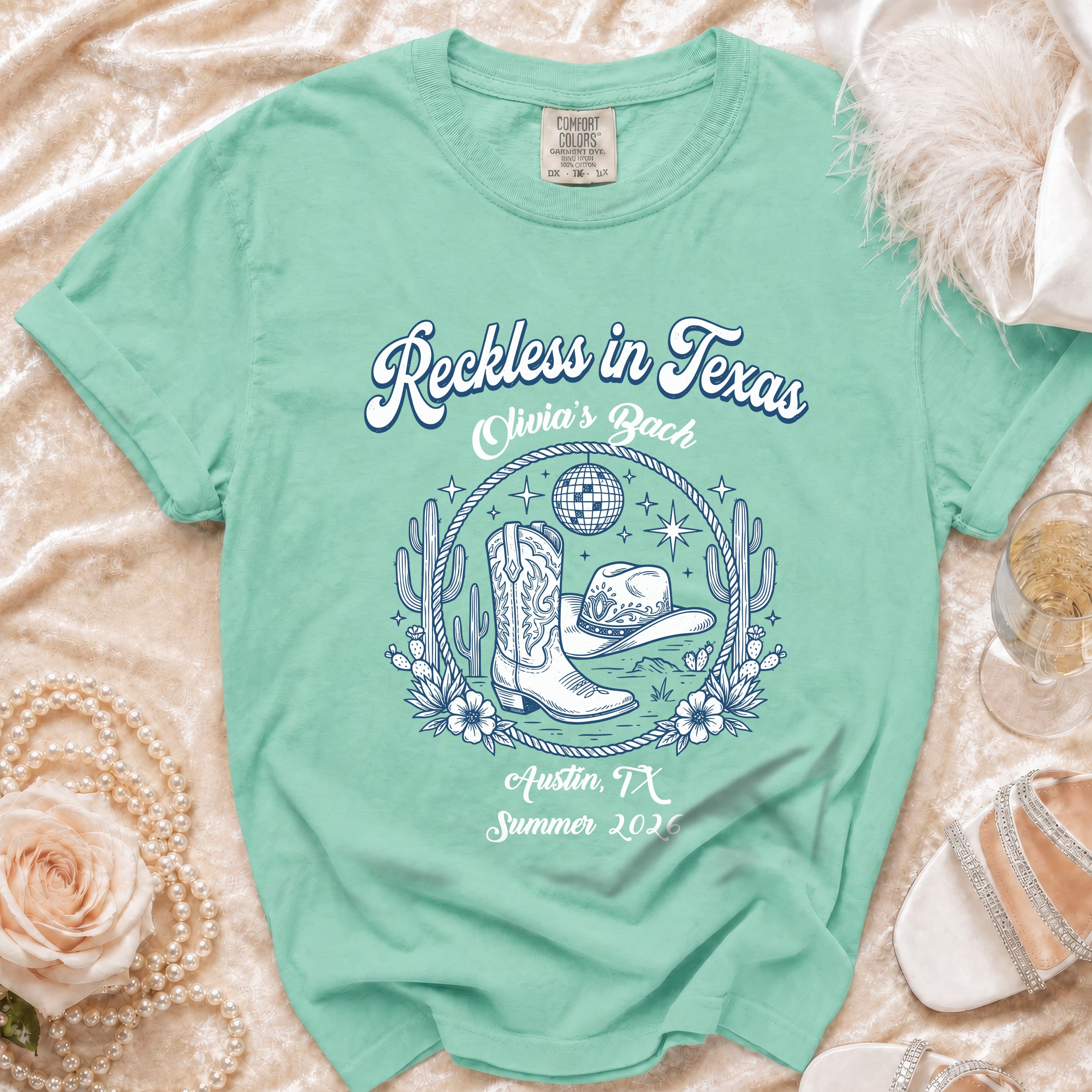 "Reckless in Texas" graphic tee with cowboy boots and hat for Olivia's Bach.