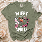 Olive t-shirt with "WIFEY Wants a Spritz" graphic, bride accessories, and champagne.