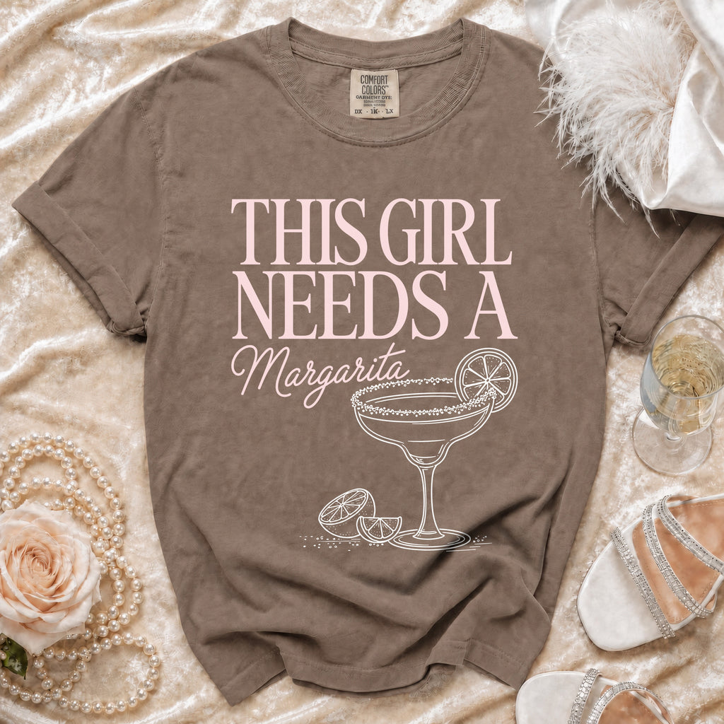 Brown t-shirt with "This Girl Needs A Margarita" text and margarita graphic.