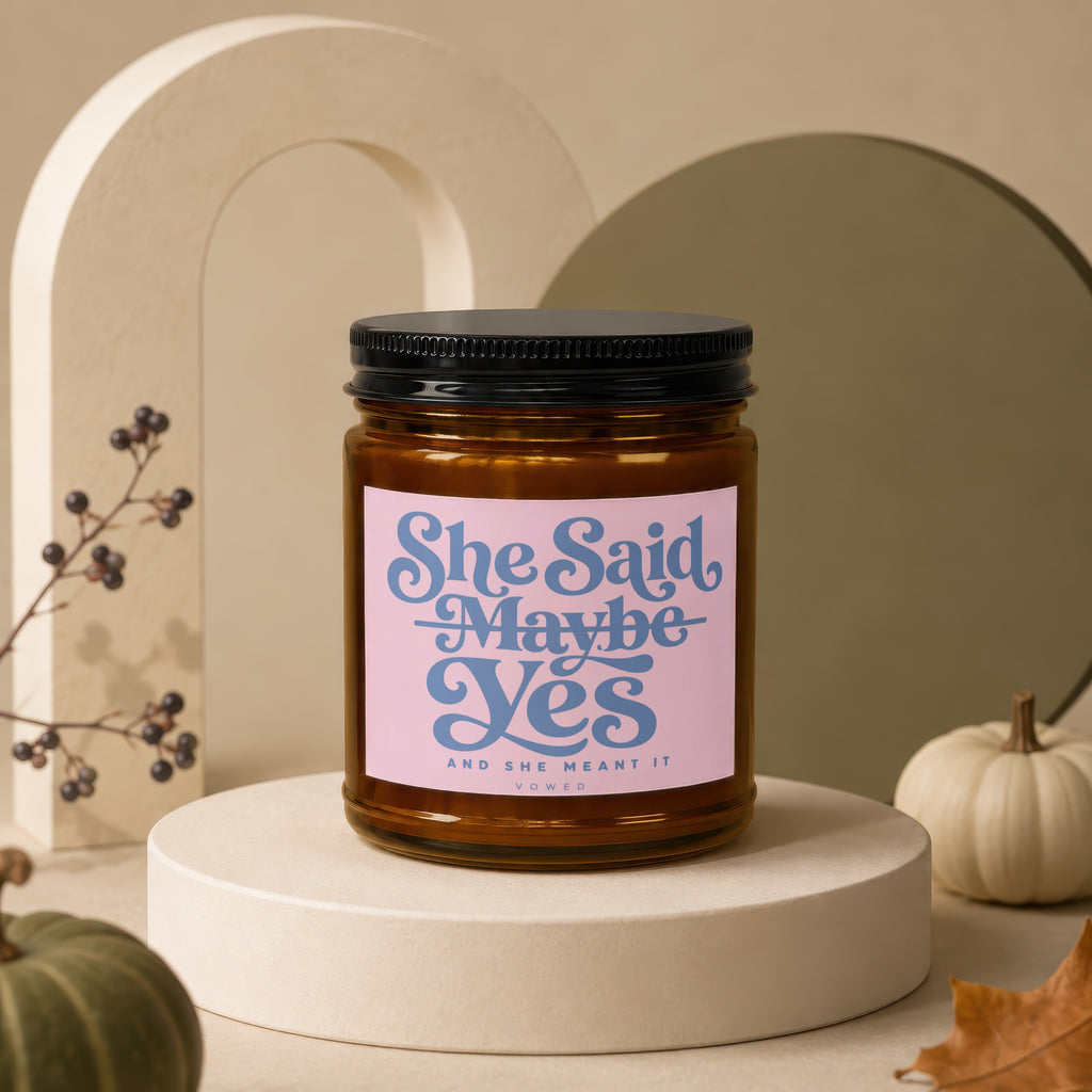 Amber jar candle with "She Said Maybe Yes And She Meant It" text on pink label.