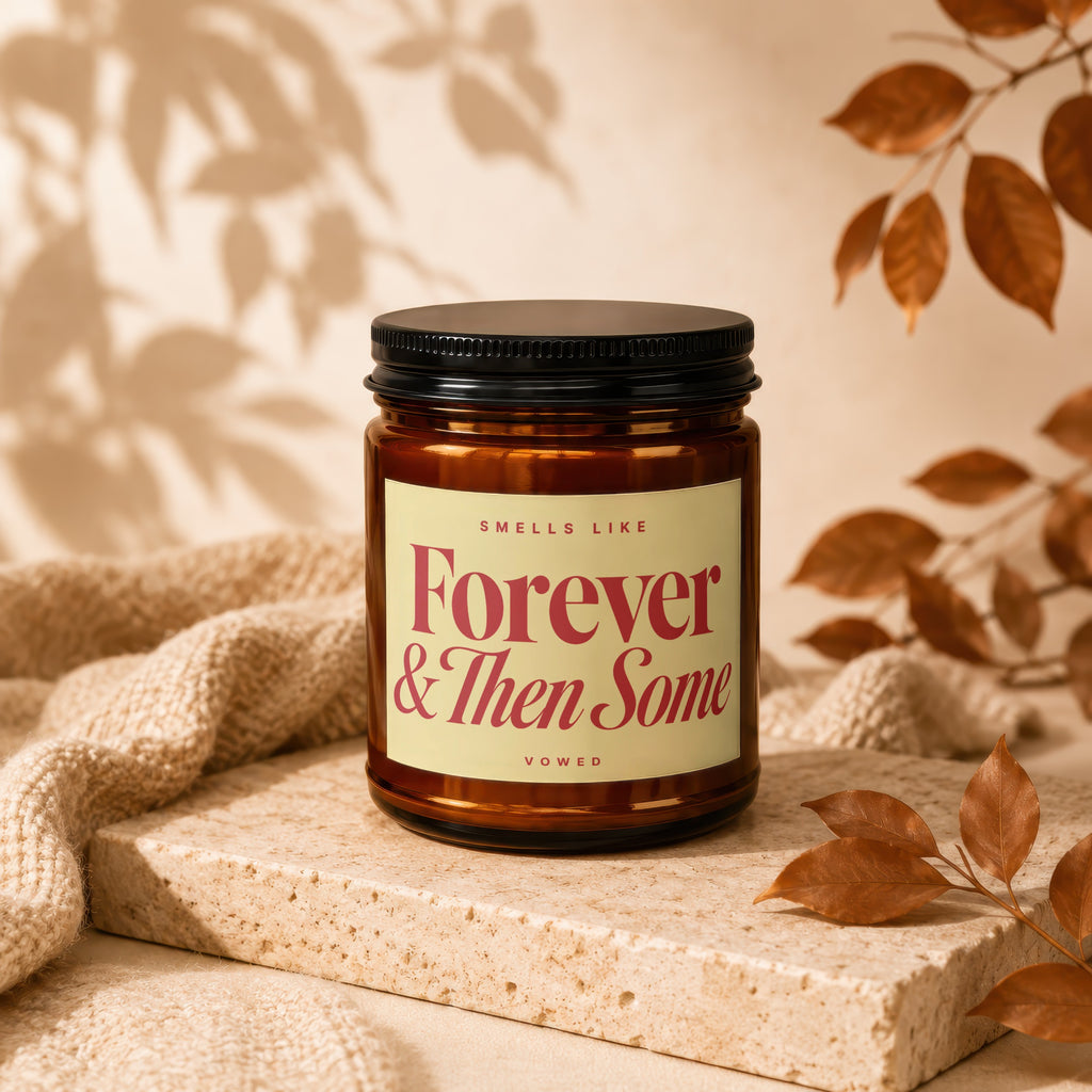Amber candle jar with black lid reading "Smells Like Forever & Then Some Vowed".