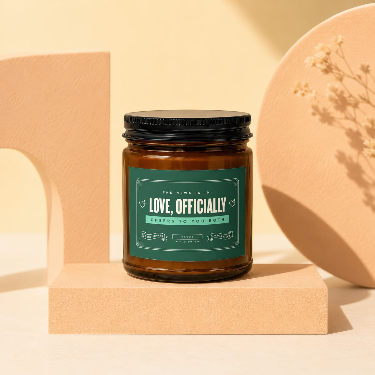 Brown glass candle with green label reading "Love, Officially" and "Cheers to You Both".