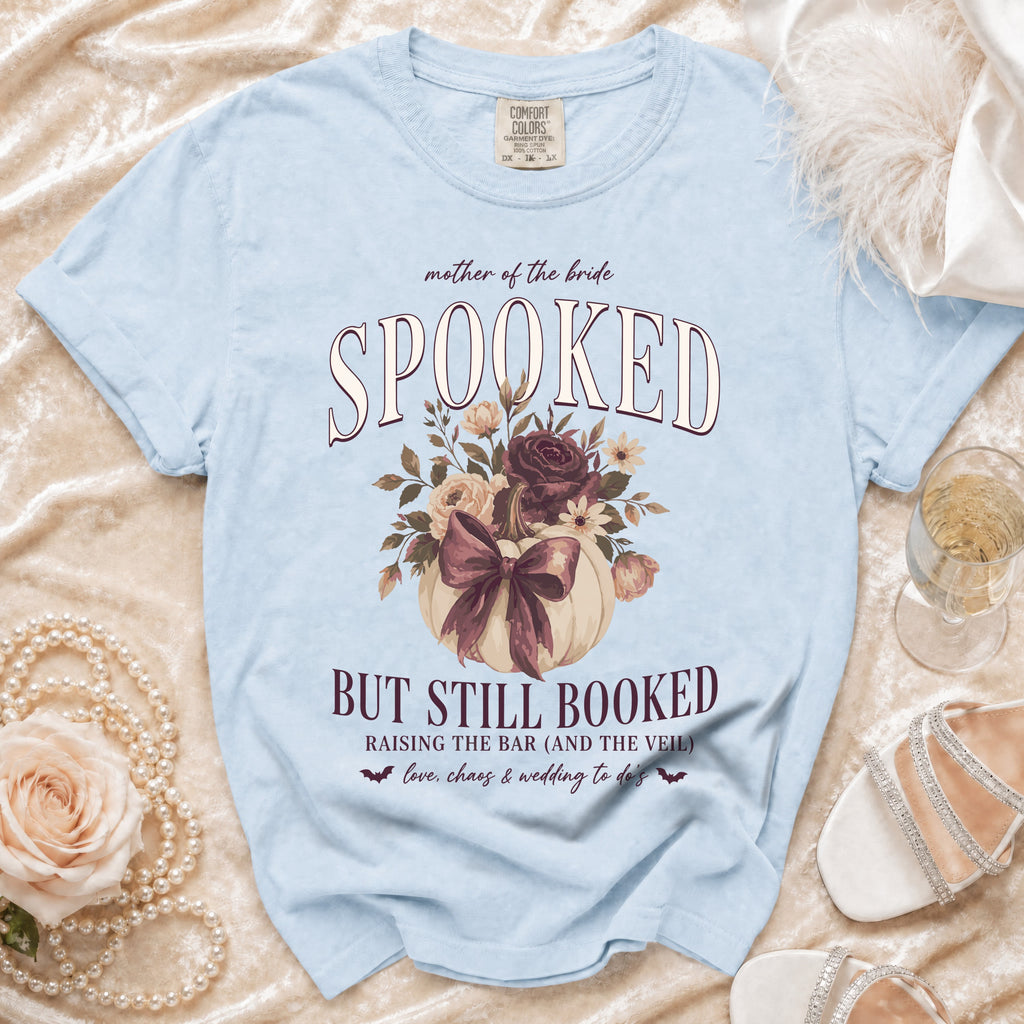 Light blue shirt with "Mother of the Bride Spooked But Still Booked" text and floral pumpkin graphic.