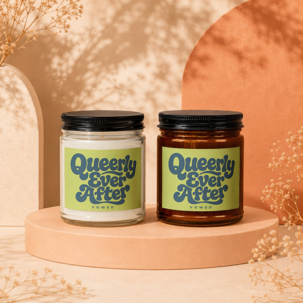 Two Vowed candles, one clear glass and one amber glass, with "Queerly Ever After" labels.