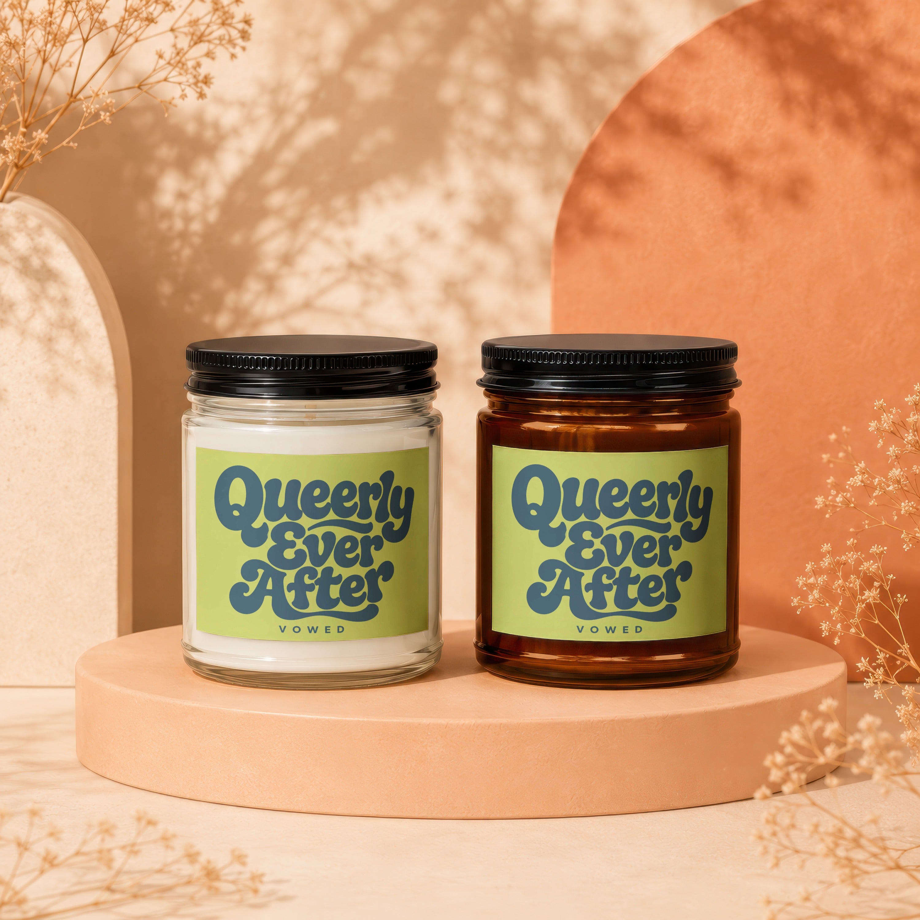 Two Vowed candles, one clear glass and one amber glass, with "Queerly Ever After" labels.