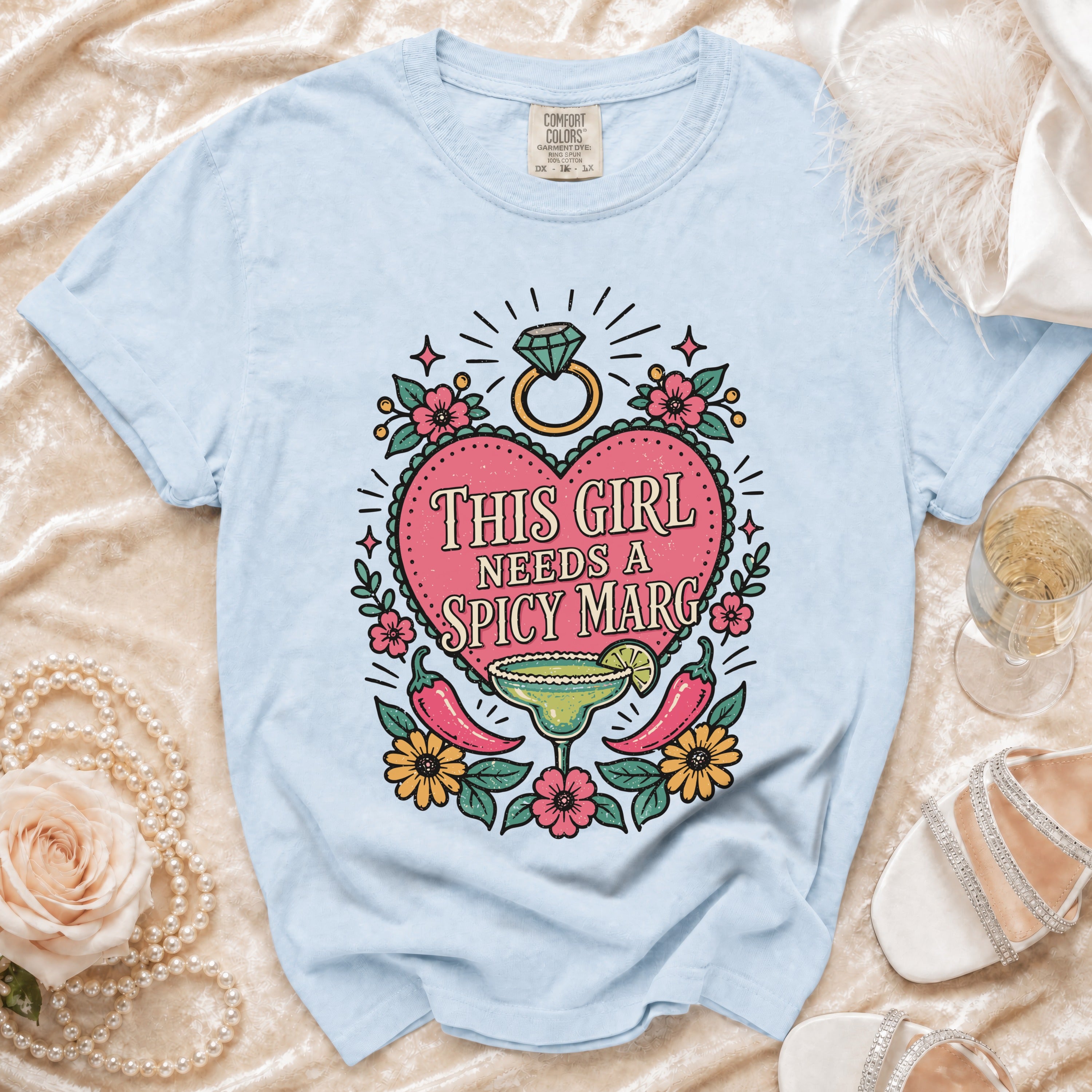 Light blue t-shirt with "This Girl Needs a Spicy Marg" graphic and ring.