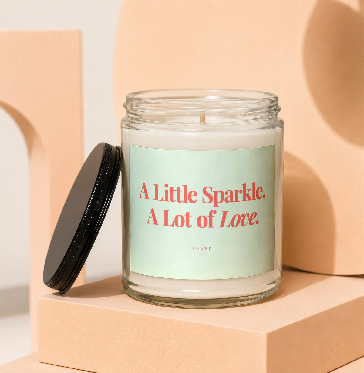 Glass candle with "A Little Sparkle, A Lot of Love" text on label.