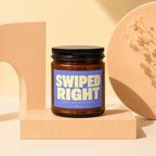 Amber glass candle with a blue label reading "SWIPED RIGHT BEST DECISION EVER VOWED".