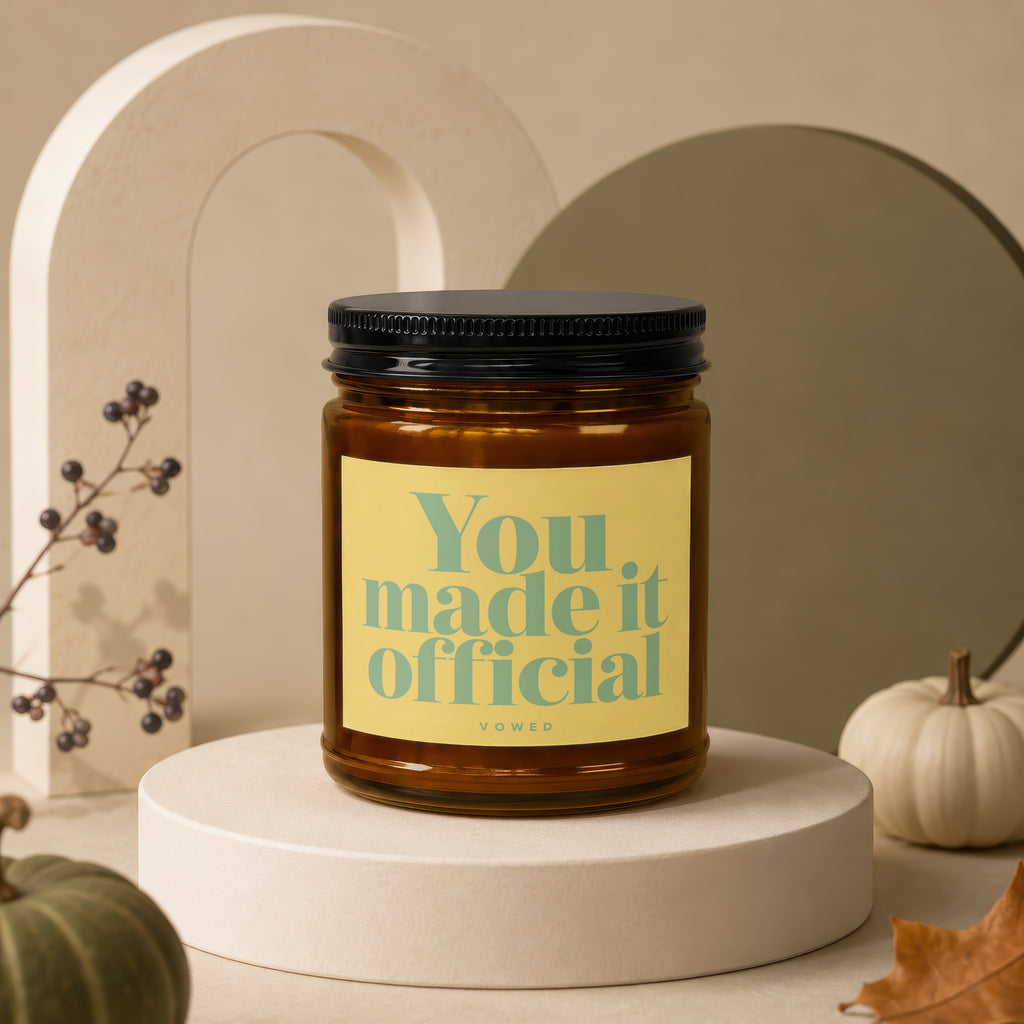 Amber candle with a yellow label that says "You made it official"