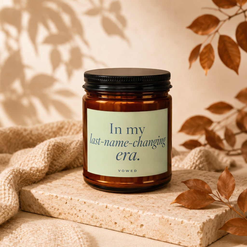Brown glass candle with "In my last-name-changing era." text and "VOWED."