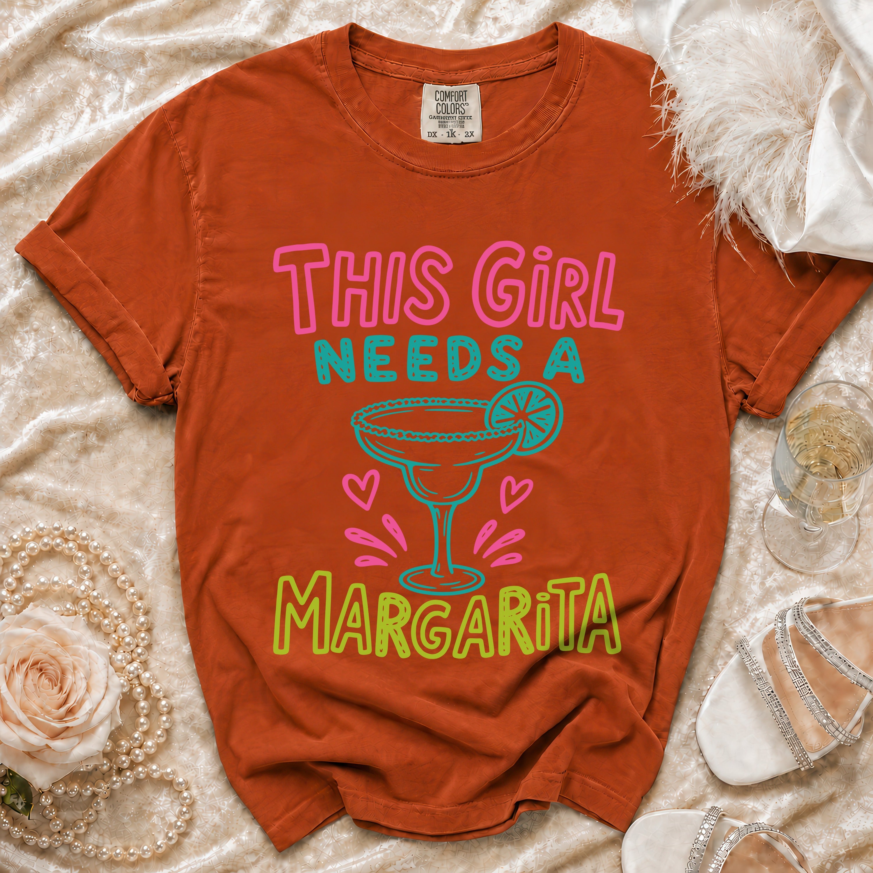 Orange t-shirt with "This Girl Needs A Margarita" and margarita graphic.