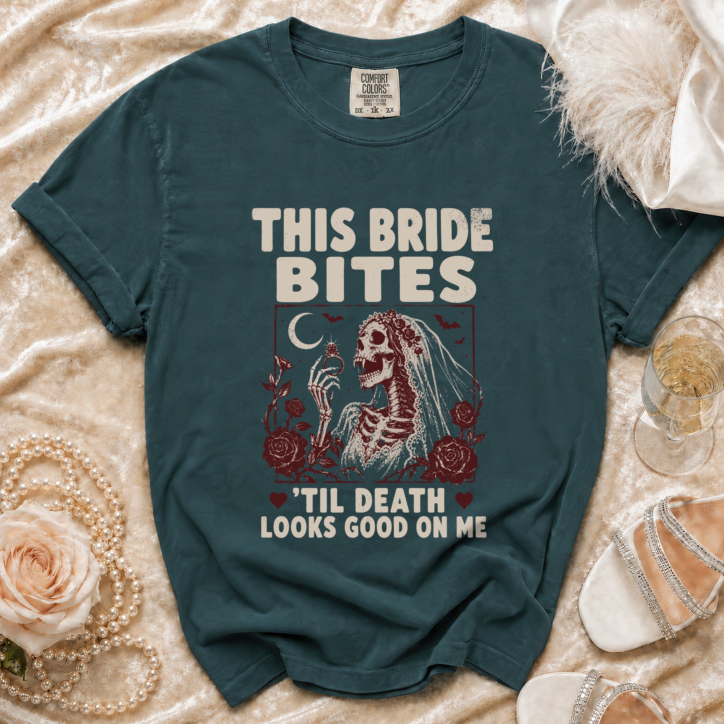 Teal t-shirt with skeleton bride graphic and text "This Bride Bites 'Til Death Looks Good On Me".