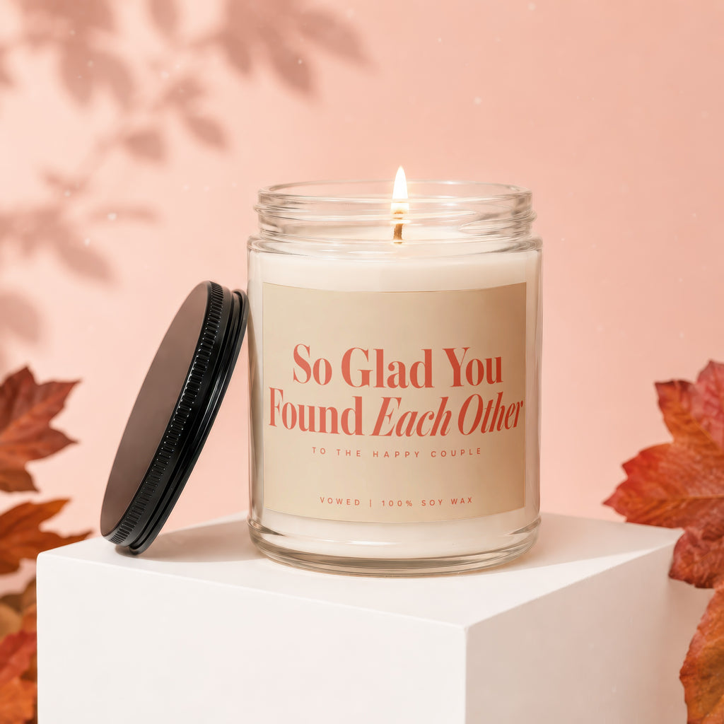 Soy candle with "So Glad You Found Each Other" text, lid off, with autumn leaves.