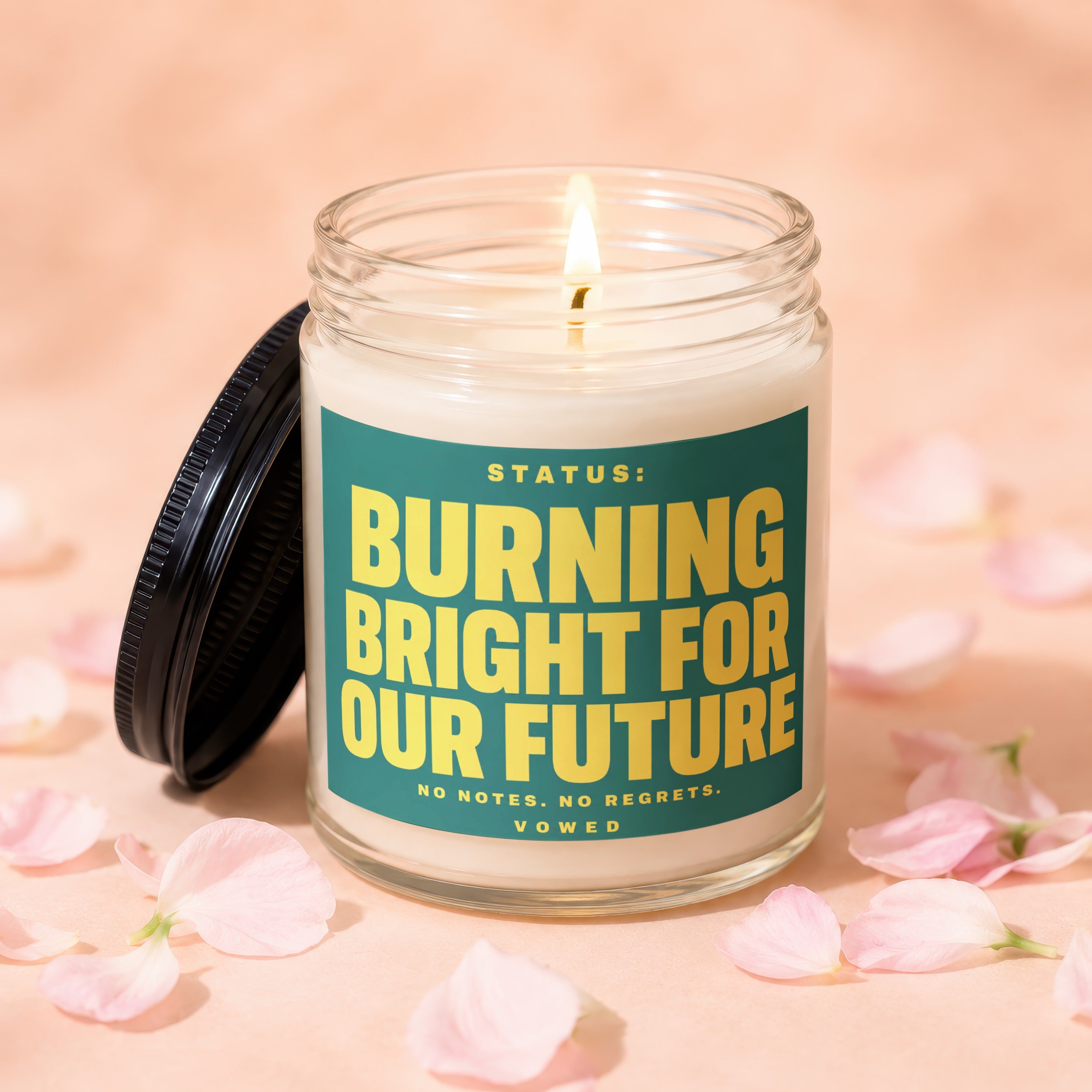 Candle with lid off, alight, reads "Burning Bright For Our Future".