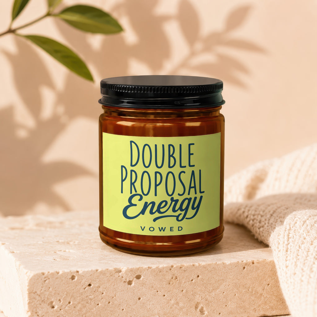 Brown glass candle with a lime green label reading "Double Proposal Energy vowed".