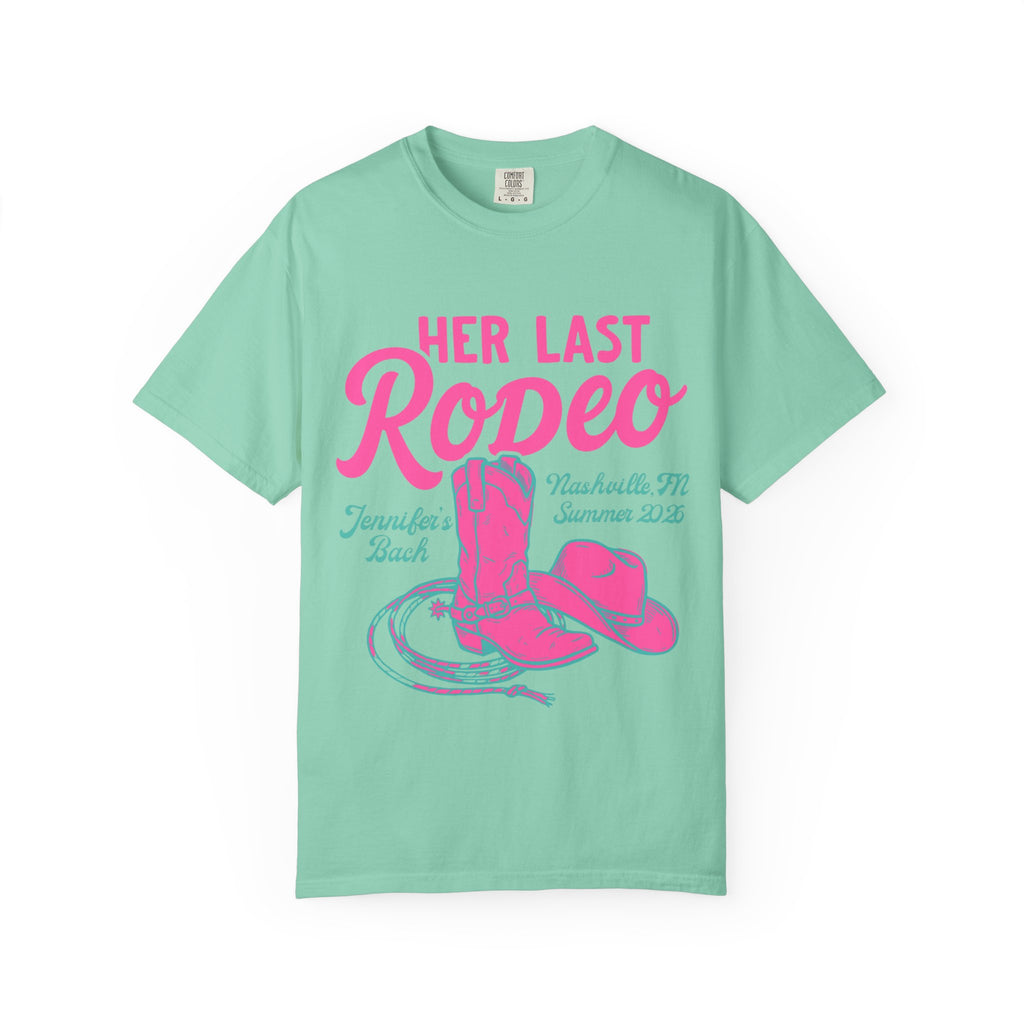 Mint t-shirt with pink "Her Last Rodeo" text, cowboy boots, and hat.