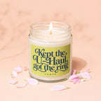 Candle with text "Kept the U-Haul, got the ring" surrounded by pink petals.