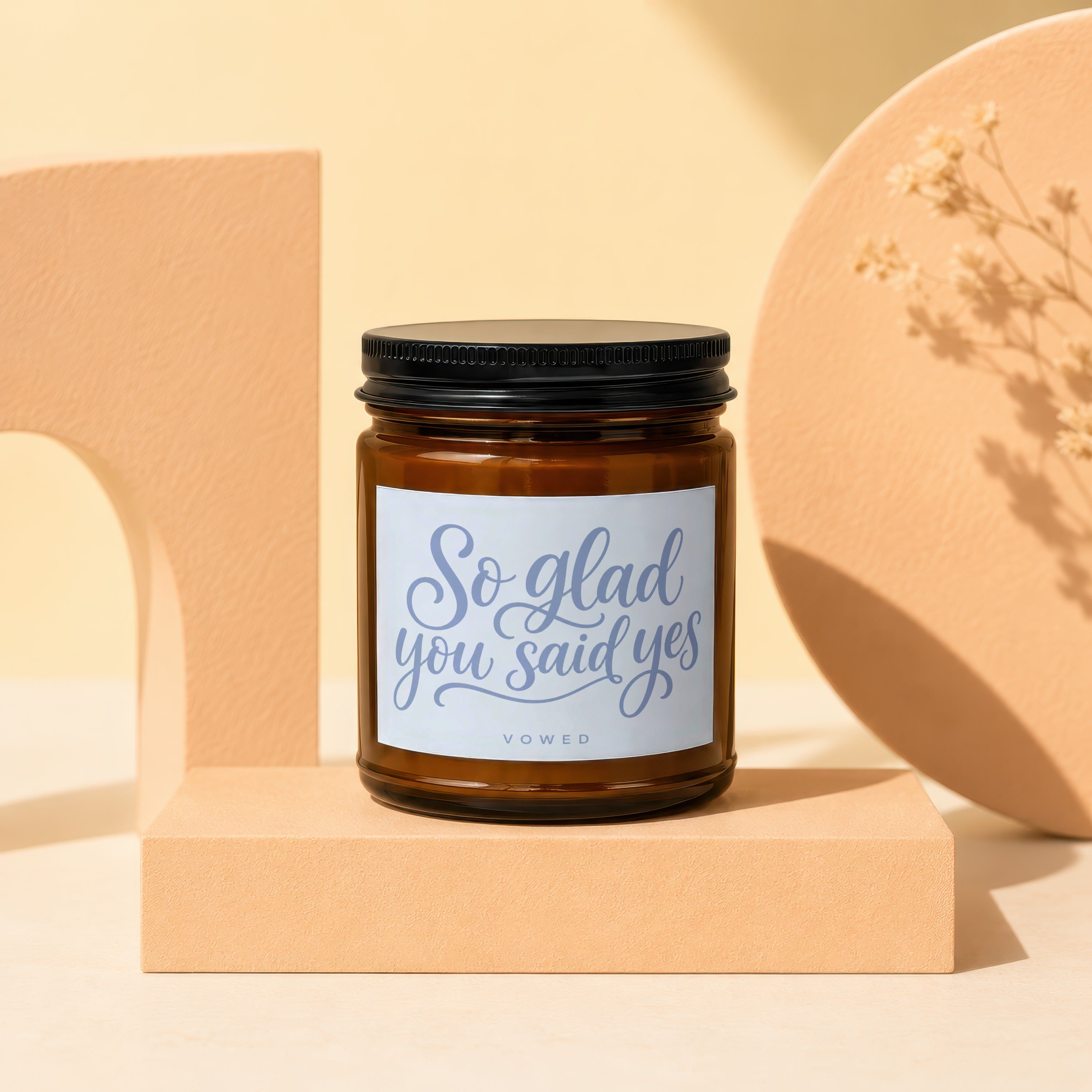 Amber glass candle with "So glad you said yes" text on label.