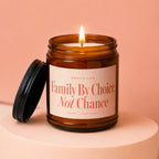 Amber jar candle with lit flame, "Family By Choice, Not Chance" text.