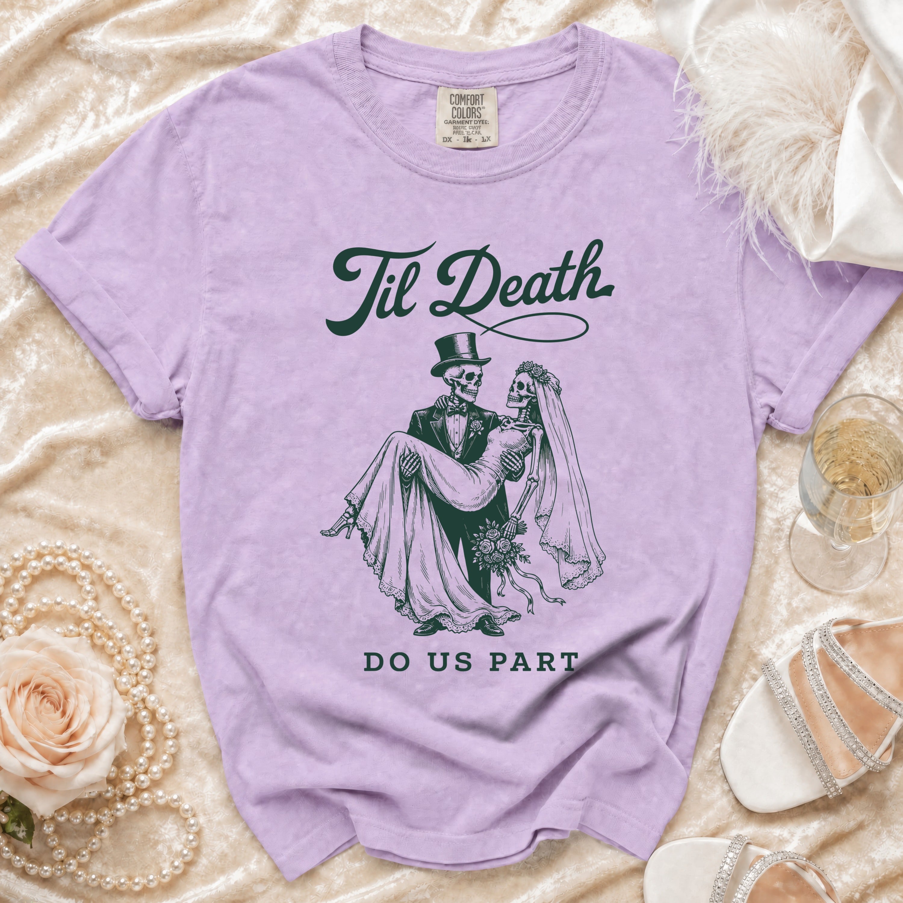 Lavender Comfort Colors shirt with skeleton bride and groom graphic and text.