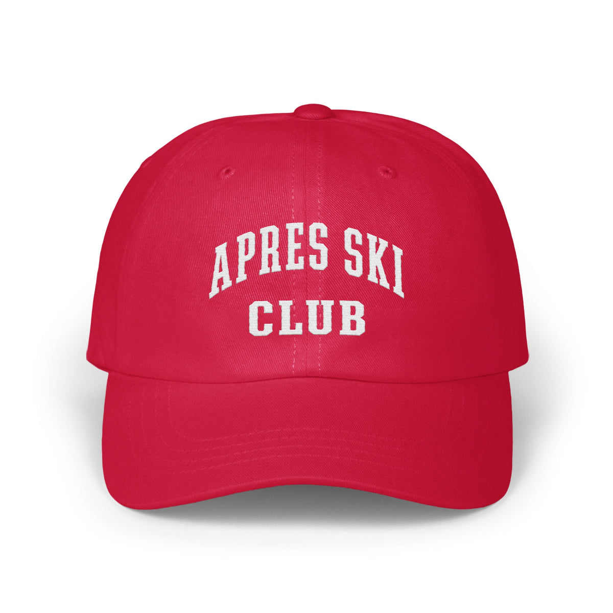 A red baseball cap with white embroidered text reading APRES SKI CLUB on the front.