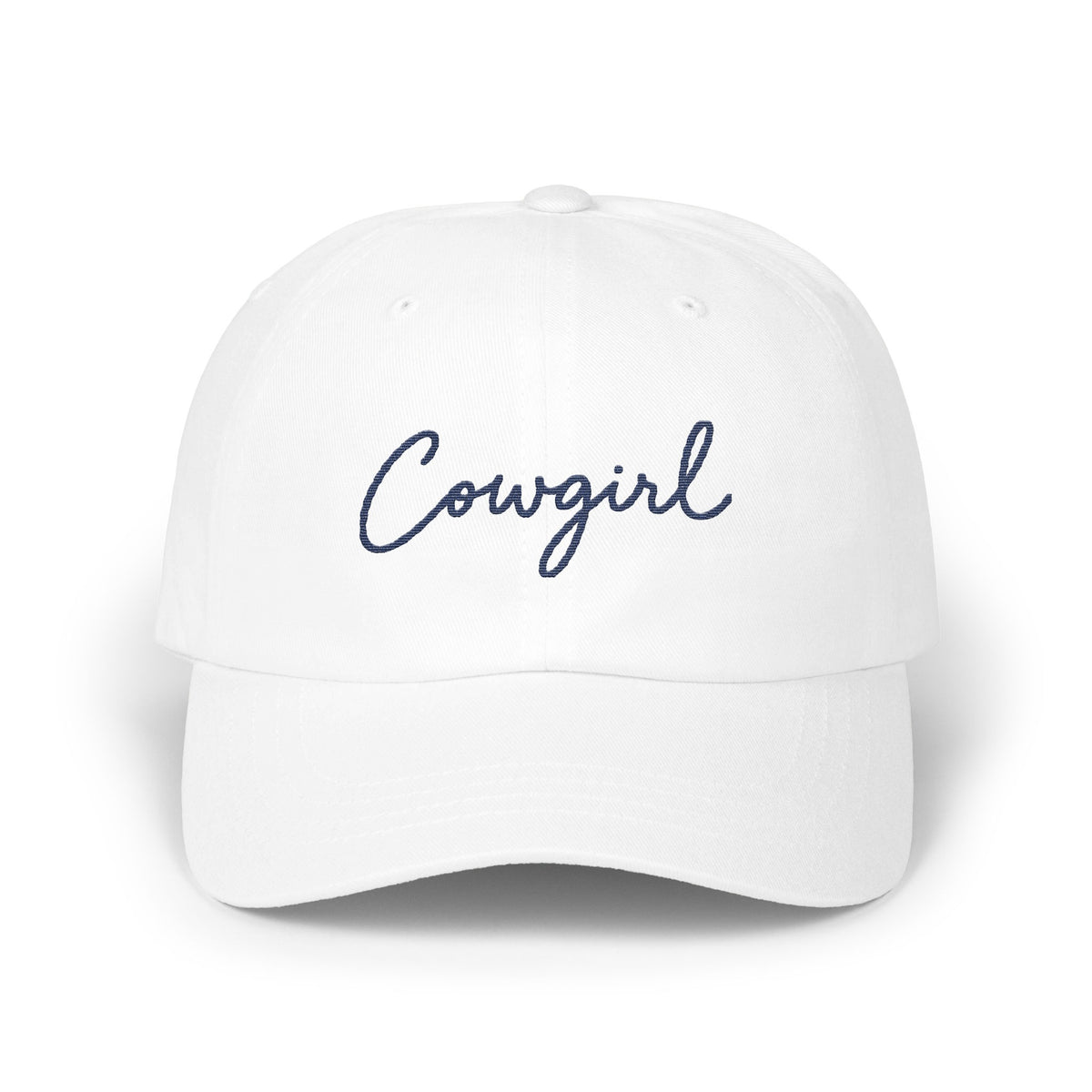 A white baseball cap with the word Cowgirl embroidered in blue cursive on the front panel.