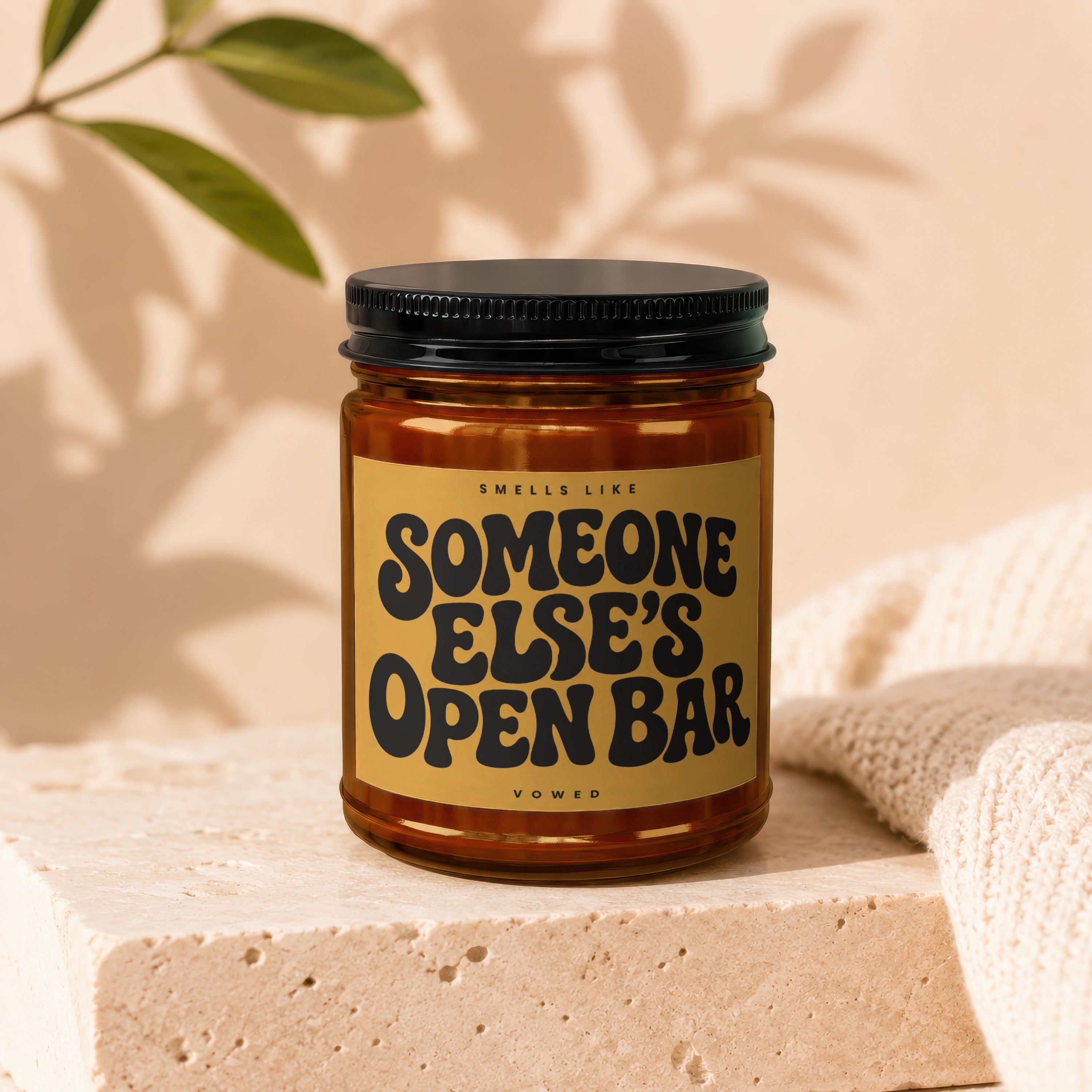 Candle with text "Smells Like Someone Else's Open Bar" on a tan label.