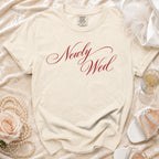Cream t-shirt with "Newly Wed" in red script, surrounded by wedding accessories.