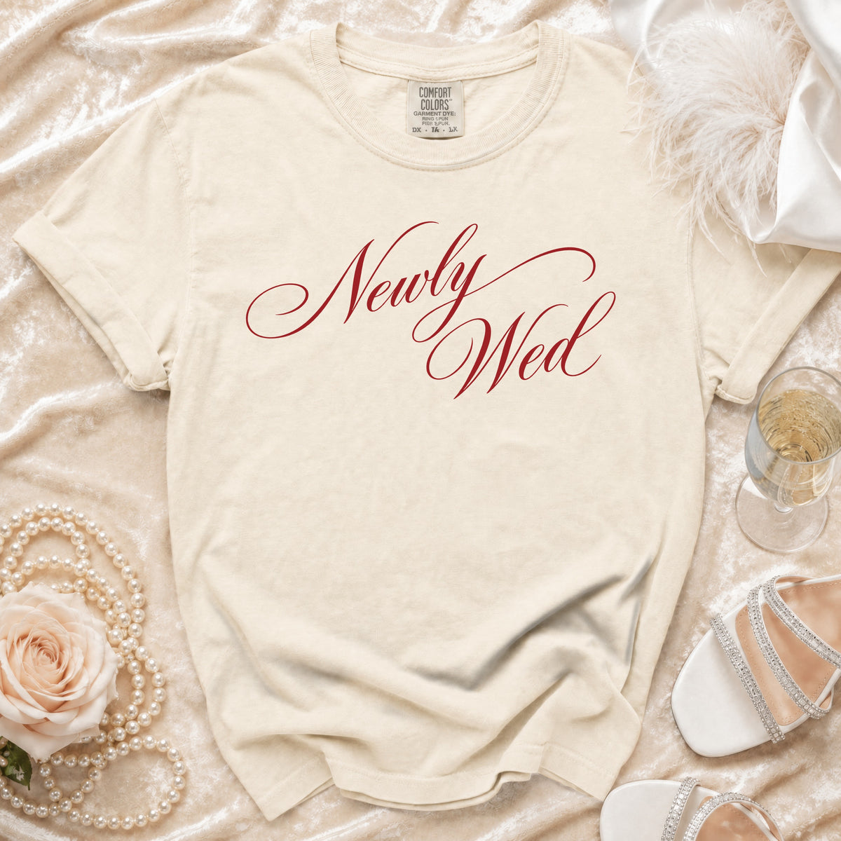 Cream t-shirt with "Newly Wed" in red script, surrounded by wedding accessories.