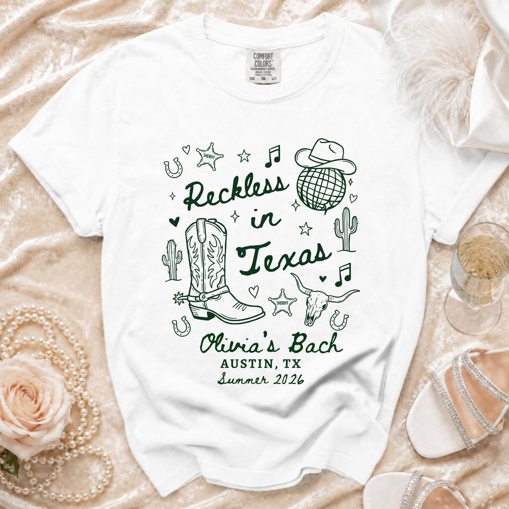 White t-shirt with "Reckless in Texas" and "Olivia's Bach Austin, TX Summer 2026".