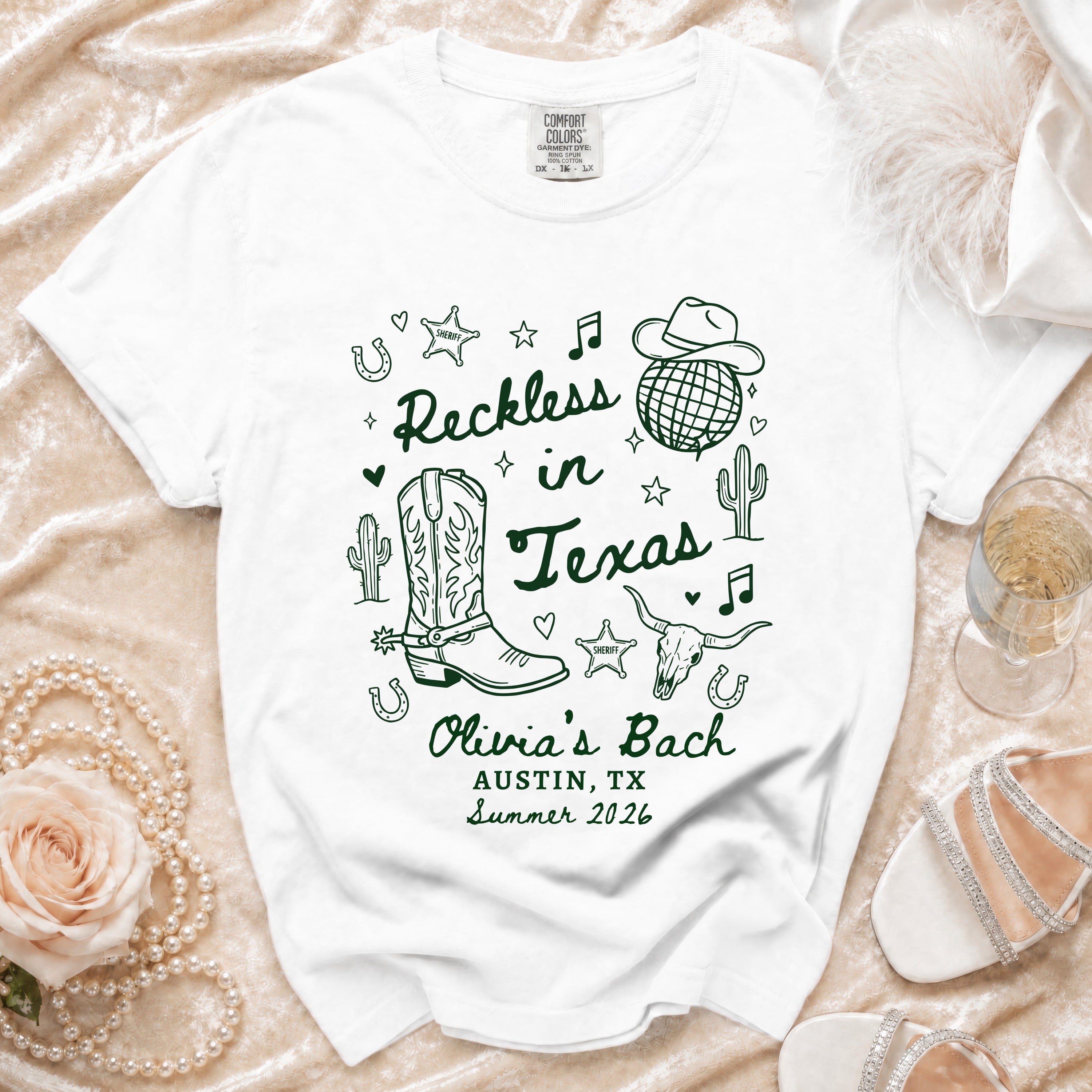 White t-shirt with "Reckless in Texas" and "Olivia's Bach Austin, TX Summer 2026".