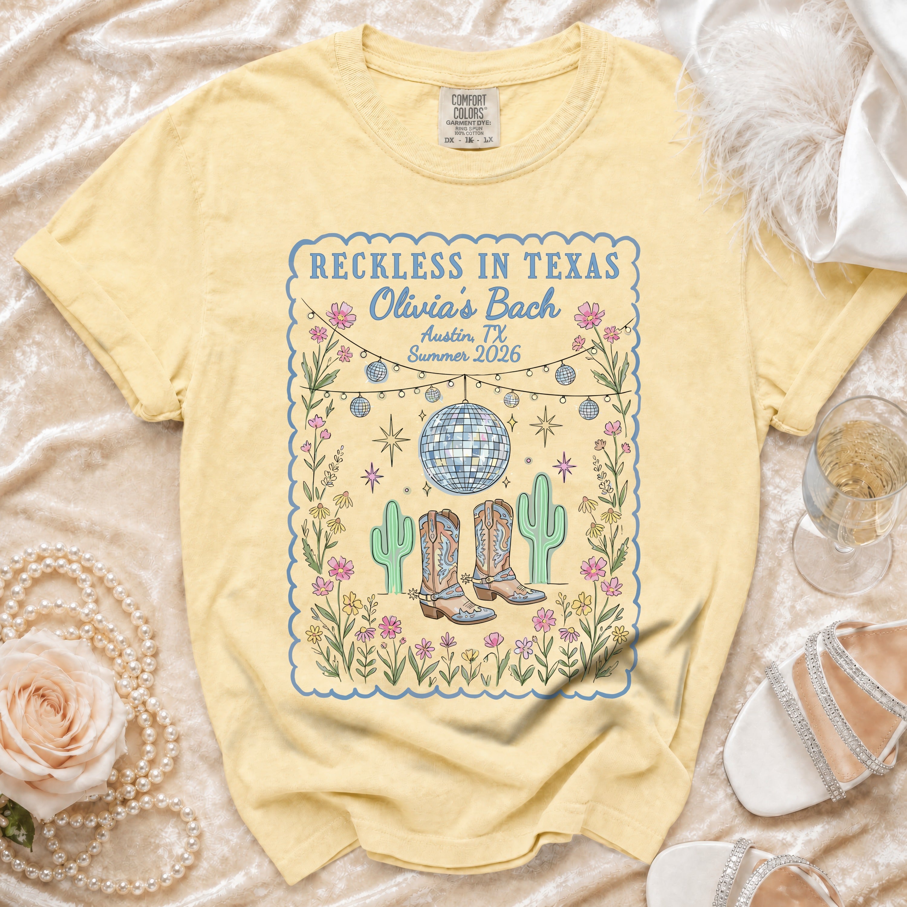 T-shirt with "Reckless in Texas Olivia's Bach Austin TX Summer 2026" text and desert boots.